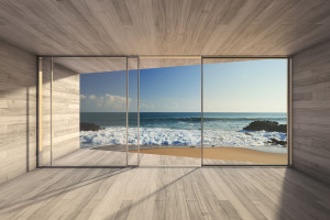 Empty modern lounge area with large bay window and view of sea